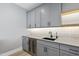 Modern wet bar with gray cabinets, quartz countertops, and a wine cooler at 7417 Dover Hills Dr, Wake Forest, NC 27587