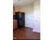 Kitchen area with dark wood cabinets, black refrigerator, and hardwood floors at 509 Hallie Long Ln, Burlington, NC 27217