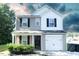 Two-story house with beige and white siding, a two-car garage, and landscaping at 509 Hallie Long Ln, Burlington, NC 27217