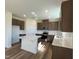 Modern kitchen with island, stainless steel appliances, and dark brown cabinets at 140 Chestnut Oak Ln, Lillington, NC 27546