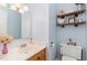 Light and airy half bathroom with wood vanity and shelving at 9500 Ligon Mill Rd, Wake Forest, NC 27587
