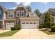 Two-story townhome with stone and siding accents, two-car garage, and landscaped front yard at 622 Chronicle Dr, Cary, NC 27513