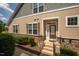 Townhome's front entrance with stone accents, dark brown door, and black railings at 622 Chronicle Dr, Cary, NC 27513