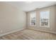 Simple bedroom with neutral walls, carpet, and two windows at 622 Chronicle Dr, Cary, NC 27513