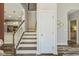 Staircase with white balusters leading to the second floor, view of kitchen in background at 622 Chronicle Dr, Cary, NC 27513