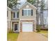 Tan two-story townhome with a white garage door and stone accents at 2833 Egert Dr, Haw River, NC 27258