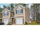 Tan two-story townhome with a white garage door and stone accents at 2833 Egert Dr, Haw River, NC 27258