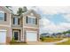 Tan two-story townhome with a white garage door and stone accents at 2833 Egert Dr, Haw River, NC 27258