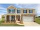 Two-story home with stone and siding exterior, two-car garage and landscaped lawn at 1713 Post Oak Dr, Haw River, NC 27258