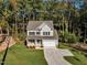Two-story house with gray siding and a two-car garage, nestled in the woods at 900 Sw Maynard Rd, Cary, NC 27511