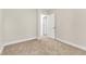 Simple bedroom with carpeted floor and neutral walls, featuring a door to hallway at 900 Sw Maynard Rd, Cary, NC 27511