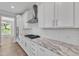 Modern kitchen with white cabinets, granite countertops, and stainless steel appliances at 900 Sw Maynard Rd, Cary, NC 27511