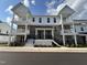 Two story townhome with white siding and brick accents at 11549 Helmond Way # 102, Raleigh, NC 27617
