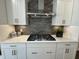 Modern gas cooktop with gray tile backsplash and white cabinets at 324 Village Walk Dr, Clayton, NC 27527