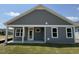 Gray house with a covered back porch and a grassy yard at 324 Village Walk Dr, Clayton, NC 27527