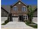 Two-story townhome with brick and stone exterior, two-car garage, and a well manicured lawn at 1055 Talisker Way # 19, Burlington, NC 27215