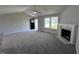 Bright living room featuring gray walls, carpeted floors, and a fireplace at 138 Lotus Ave, Smithfield, NC 27577