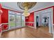 Bright dining room features hardwood floors, red walls, and a crystal chandelier at 19 Silverside Dr, Angier, NC 27501