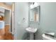 Powder room with pedestal sink, gold fixtures, and light teal walls at 3614 Lion Ridge Ct, Raleigh, NC 27612