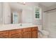 Clean bathroom with wood vanity, bathtub, and updated fixtures at 2200 Becketts Ridge Dr, Hillsborough, NC 27278