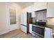 Modern kitchen with stainless steel appliances and white cabinets at 1203 Keith Hills Rd, Lillington, NC 27546