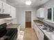 Kitchen boasts white cabinets, tile floors, and black appliances at 105 Tottingham Ct, Garner, NC 27529