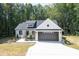 White farmhouse exterior with black garage door and landscaping at 114 Shaman Dr, Louisburg, NC 27549