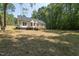 White house back with deck, surrounded by trees and a large yard at 114 Shaman Dr, Louisburg, NC 27549