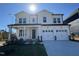 Two-story white farmhouse-style home with a two-car garage and landscaped lawn at 1005 Bostonian Dr, Knightdale, NC 27545