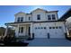 Two-story white farmhouse-style home with a two-car garage and landscaped lawn at 1005 Bostonian Dr, Knightdale, NC 27545