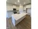 Modern kitchen with island, white cabinets, and quartz countertops at 60 Sawtooth Oak Ln, Youngsville, NC 27596