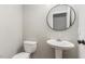Clean bathroom with pedestal sink and round mirror at 2113 Eveton Ln, Sanford, NC 27330