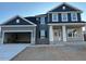 Two-story home with gray and blue siding, stone accents, and a two-car garage at 84 Rosslyn Way # 92, Garner, NC 27529