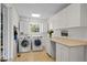 Bright laundry room with washer, dryer, cabinets, and countertop at 11609 Us-401, Fuquay Varina, NC 27526