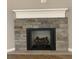 Modern fireplace with a stone facade and wooden mantel at 35 Courtland Dr, Louisburg, NC 27549