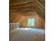 Spacious unfinished attic room with large window and wood beams at 35 Courtland Dr, Louisburg, NC 27549