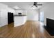 Open living room features hardwood floors, a kitchen with white cabinets, and a fireplace at 5107 Sandy Banks Rd, Raleigh, NC 27616