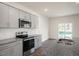 Eat-in kitchen featuring gray cabinets, granite countertops, and a sliding glass door to the backyard at 35 Finsbury Ct, Lillington, NC 27546