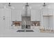 Modern kitchen features white cabinets, a stainless steel range and a large island at 3005 Corbell Rd, Durham, NC 27701