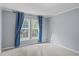 Bright bedroom with carpet, neutral walls, and two large windows with blue curtains at 126 Yuma Dr, Louisburg, NC 27549