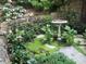 Landscaped garden with stone walls, bird bath, and lush greenery at 50211 Manly, Chapel Hill, NC 27517