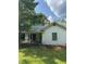 A white, ranch-style house with a covered porch and mature trees in the front yard at 4285 Belltown Rd, Oxford, NC 27565
