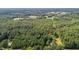 Aerial view of a large lot with mature trees and a small house in the distance at 4285 Belltown Rd, Oxford, NC 27565