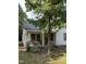 A white, ranch-style house with a covered porch and mature trees in the front yard at 4285 Belltown Rd, Oxford, NC 27565