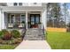 Front entry with stone steps, wooden door, and landscaping at 600 Darian Woods Drive,, Holly Springs, NC 27540