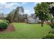 Spacious backyard with grassy lawn, mature trees, and neatly landscaped borders at 600 Darian Woods Drive,, Holly Springs, NC 27540
