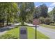 Residential street in the Main Street Historic District, featuring mature trees and a stone marker at 214 College St, Oxford, NC 27565