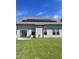 Home's back with solar panels, patio, and a green lawn at 1565 Sage Treee Dr Dr, Zebulon, NC 27597