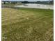 Large backyard with pond view, partially fenced, and grassy area at 1565 Sage Treee Dr Dr, Zebulon, NC 27597