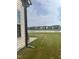 Spacious backyard with a patio, offering a peaceful view of a pond and houses at 1565 Sage Treee Dr Dr, Zebulon, NC 27597